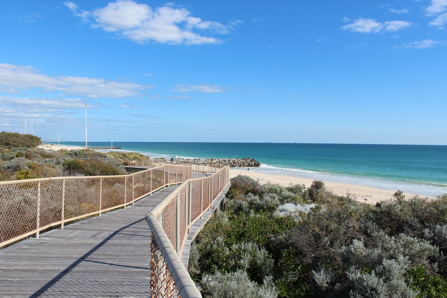 Wooden walkway between Floreat and iconic City beaches Perth Western Australia on a fine afternoon in early spring has scenic views of the Indian Ocean and dune rehabilitation.